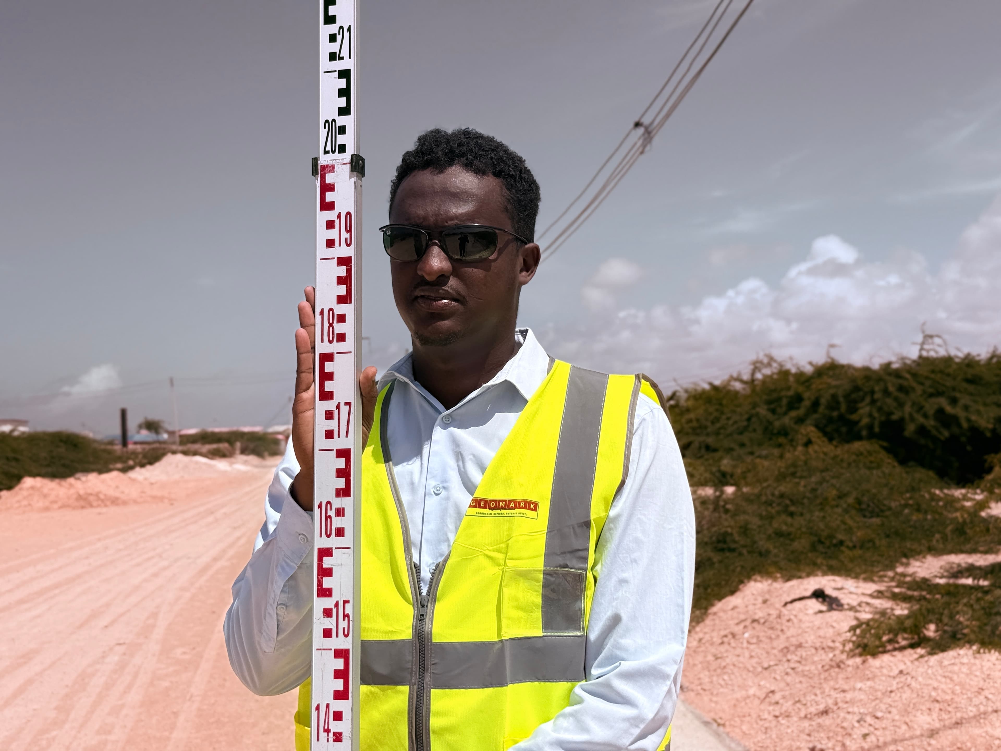 GEOMARK engineer with precision level staff for elevation survey